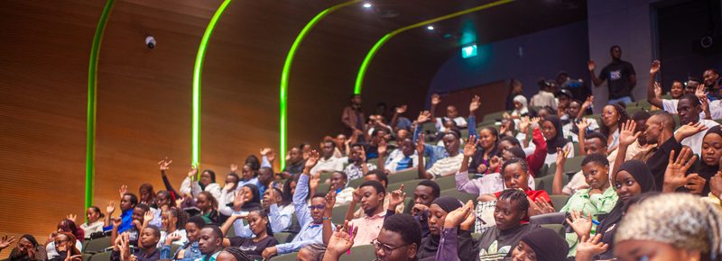 Youth audience raising hands during a Digital Economy Africa engagement event